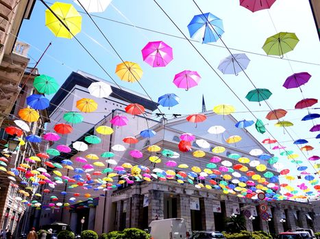 Genova, Italy - 06/01/2020: Bright abstract background of jumble of rainbow colored umbrellas over the city celebrating gay pride