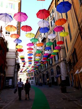 Genova, Italy - 06/01/2020: Bright abstract background of jumble of rainbow colored umbrellas over the city celebrating gay pride