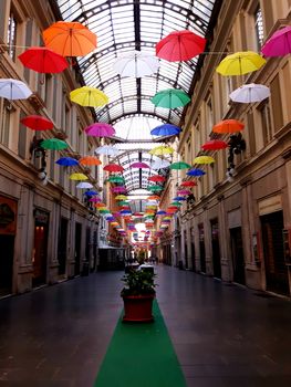 Genova, Italy - 06/01/2020: Bright abstract background of jumble of rainbow colored umbrellas over the city celebrating gay pride