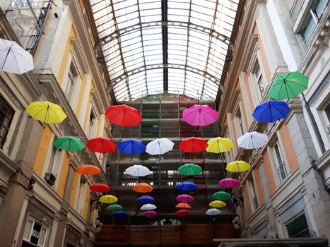 Genova, Italy - 06/01/2020: Bright abstract background of jumble of rainbow colored umbrellas over the city celebrating gay pride