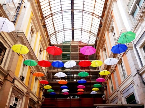 Genova, Italy - 06/01/2020: Bright abstract background of jumble of rainbow colored umbrellas over the city celebrating gay pride