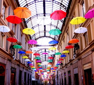 Genova, Italy - 06/01/2020: Bright abstract background of jumble of rainbow colored umbrellas over the city celebrating gay pride