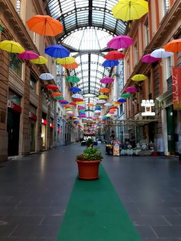 Genova, Italy - 06/01/2020: Bright abstract background of jumble of rainbow colored umbrellas over the city celebrating gay pride