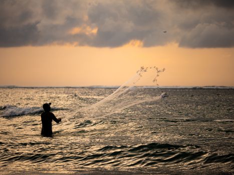 Fisherman on the beach at sunset in Bali Indonesia