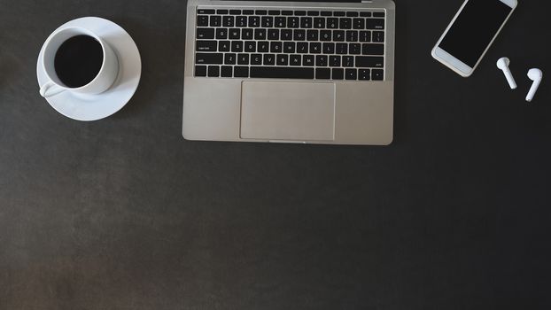 Top view flat lay office desk leather with laptop, mobile phone, earphones with coffee.