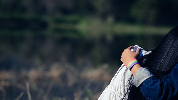 Copy space of LGBT couple embracing and showing a LGBT bracelet from the behind view. LGBT happiness concept.