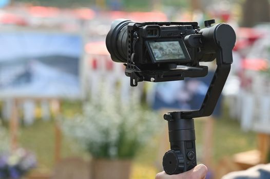 The photographer Video camera operator on stabilizers working with his equipment to pay close attention to take a photo. 