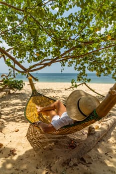 Woman relaxing at the beach on a hammock