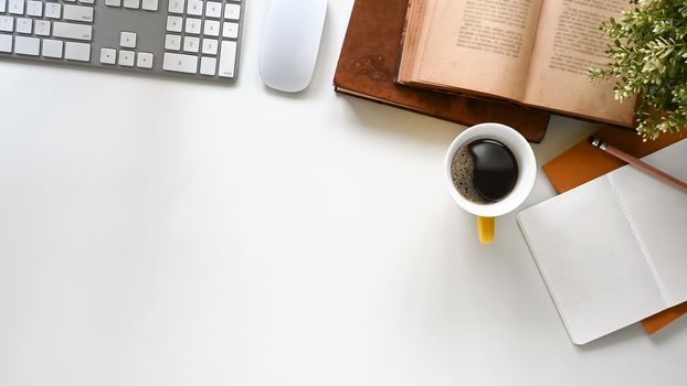 Office desk of keyboard, coffee cup, books, note and pencil all of these is putting on the modern office desk.