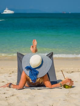 Woman enjoying her holidays on a transat at the tropical beach in Thailand - UNRETOUCHED body.