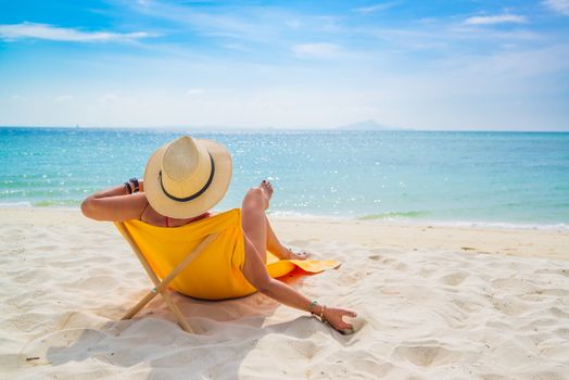 Woman enjoying her holidays on a transat at the tropical beach in Thailand