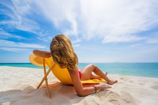 Woman enjoying her holidays on a transat at the tropical beach in Thailand