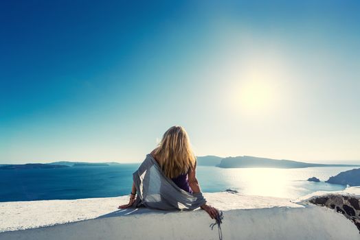 Luxury travel vacation woman looking at view on Santorini island in Greece. Amazing view of sea and Caldera.