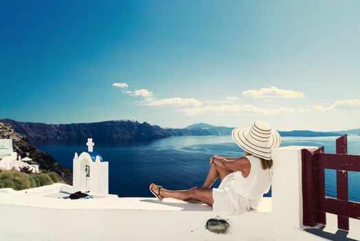 Luxury travel vacation woman looking at view on Santorini island in Greece. Amazing view of sea and Caldera.