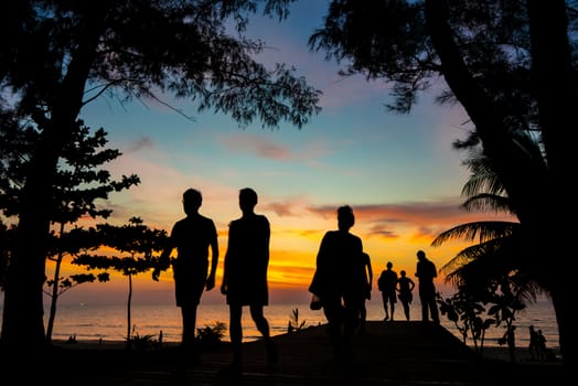 People on the bach at Sunset on Karon beach Phuket Thailand
