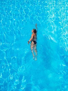 Top view of a woman swimming in the pool