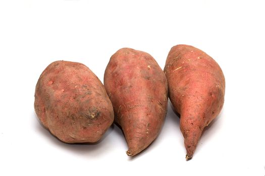 An arrangement of raw sweet potato tubers on a white background