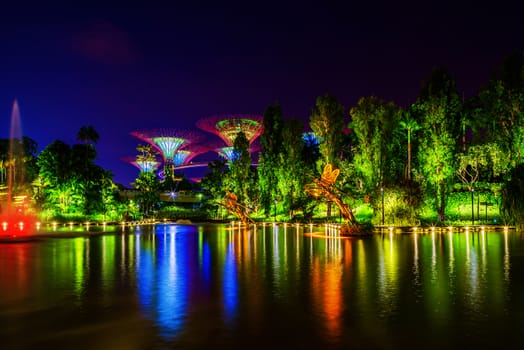SINGAPORE - APRIL 21 2018 : Singapore Night Skyline at Gardens by the Bay. SuperTree Grove under Blue Night Sky in Singapore. Cityscape and city skyline in Singapore.