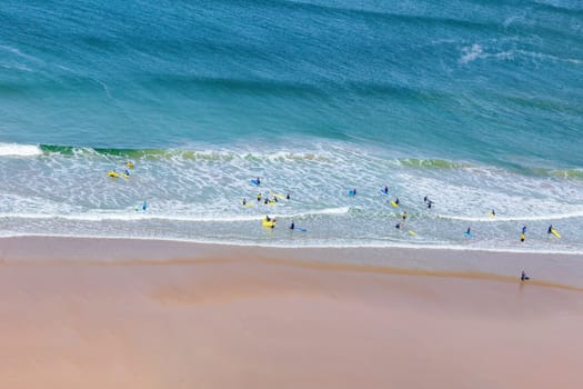 Surfers in the waves off Mawgan Porth Beach, Cornwall, UK