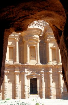 The Al-Deir Monastery in the mountains of Petra, Jordan, framed by the rocks of a cave, middle east