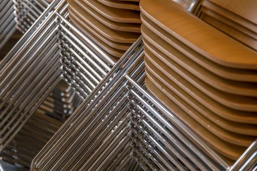 Stacked chairs with wooden seats and metallic legs