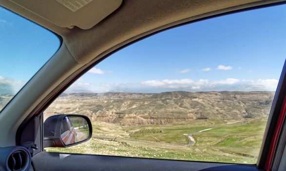 View through the window of a rental car to the edge of Dana Biosphere Reserve, Jordan, middle east