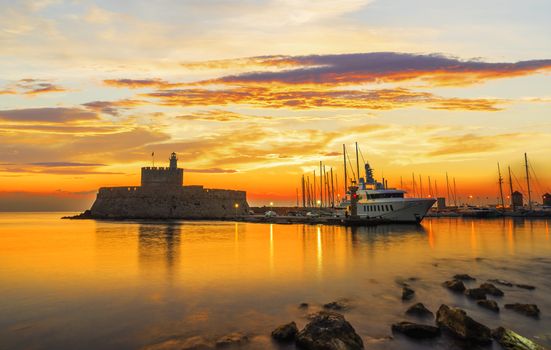 Agios Nikolaos fortress on the Mandraki harbour of Rhodes Greece at sunset