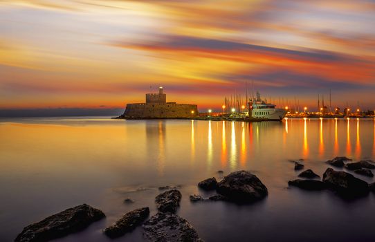 Agios Nikolaos fortress on the Mandraki harbour of Rhodes Greece at sunrise
