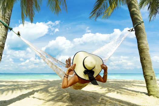 Woman relaxing at the beach on a hammock