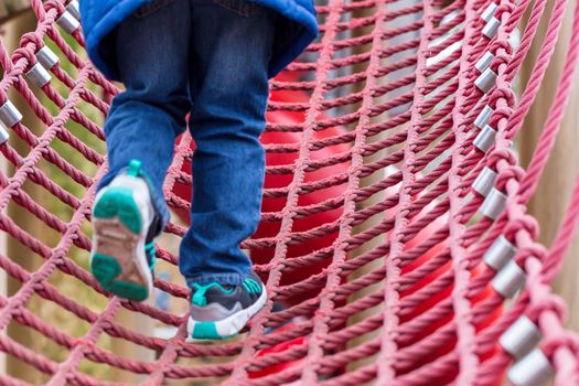 Young boy on a rope climbing frame