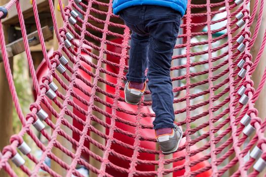 Young boy on a rope climbing frame