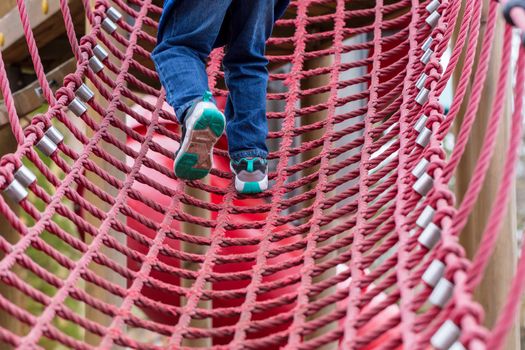 Young boy on a rope climbing frame