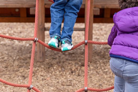 Young children playing on a climbing frame at Battersea Park, London