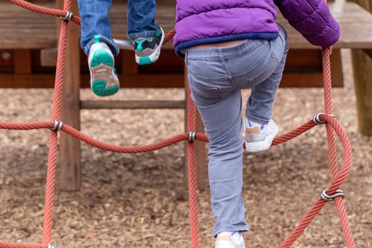 Young children playing on a climbing frame at Battersea Park, London