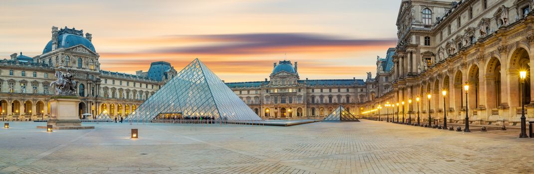 PARIS, FRANCE - DECEMBER 02, 2017: View of famous Louvre Museum with Louvre Pyramid at sunrise. Louvre Museum is one of the largest and most visited museums worldwide