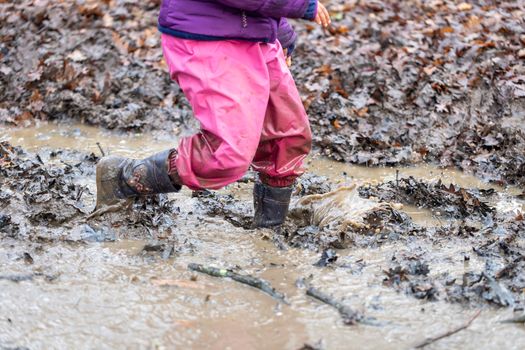 Young child playing in a mud puddle