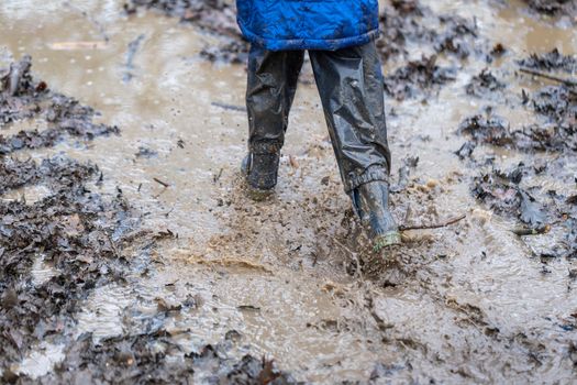 Young child playing in a mud puddle