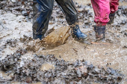 Young child playing in a mud puddle