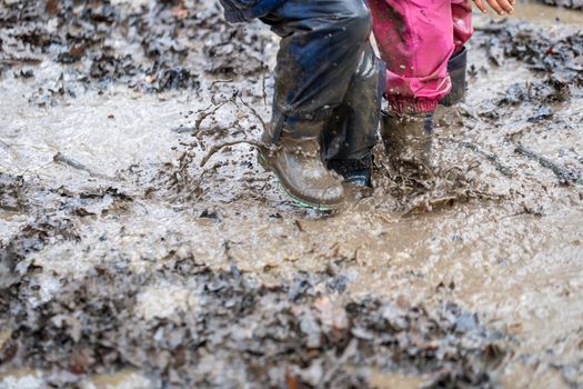 Young child playing in a mud puddle