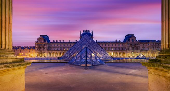 PARIS, FRANCE - DECEMBER 02, 2017: View of famous Louvre Museum with Louvre Pyramid at evening. Louvre Museum is one of the largest and most visited museums worldwide