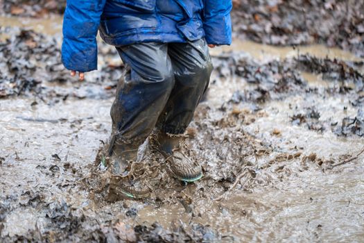 Young child playing in a mud puddle