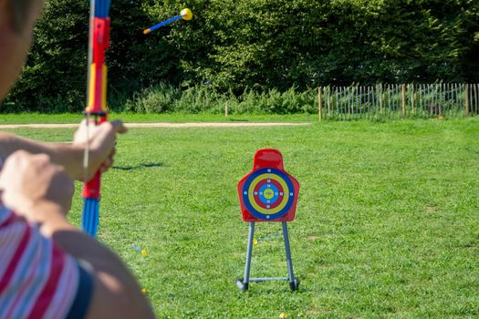 Man playing with a toy archery set in a field