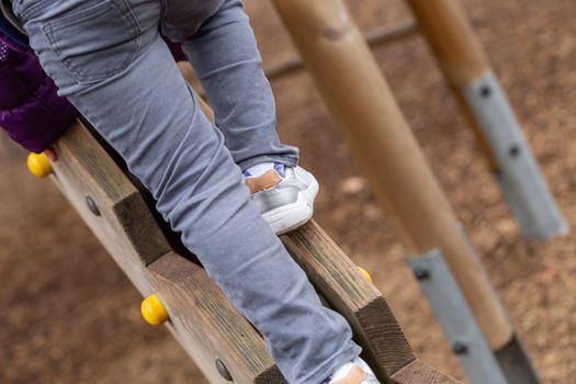 A young boy on a wooden climbing frame in Battersea Park, London