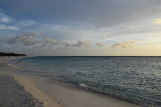 Beautiful golden sunset on the white beach of Aruba with turquoise water