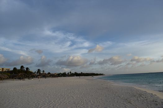 Beautiful golden sunset on the white beach of Aruba with turquoise water