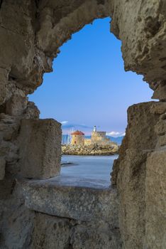 Agios Nikolaos fortress on the Mandraki harbour of Rhodes Greece at dusk