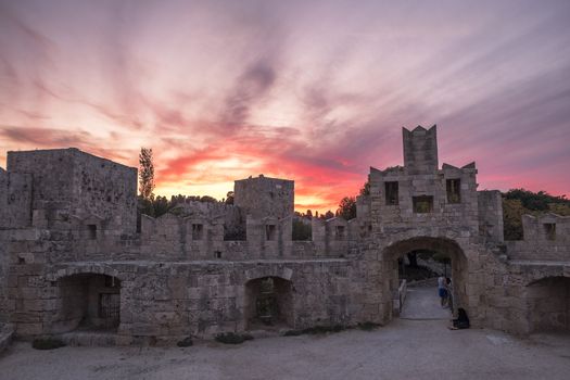 The fortress wall in the harbor at sunset. Rhodes, Greece