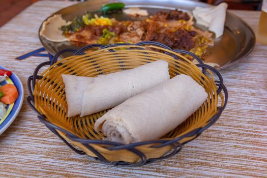 Rolls of Injera in a serving bowl.  Injera is a sourdough flatbread made from teff flour.  It is the national dish of Ethiopia, Eritrea, Somalia and Djibouti