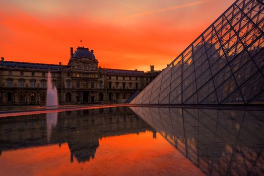 PARIS, FRANCE - DECEMBER 9, 2017: View of famous Louvre Museum with Louvre Pyramid at evening. Louvre Museum is one of the largest and most visited museums worldwide