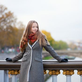 Beautiful young lady in Paris on a bridge